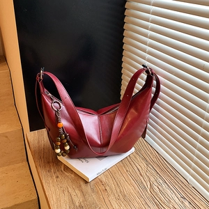 Sac bandoulière demi-lune rouge foncé en cuir brillant avec pendentif perlé