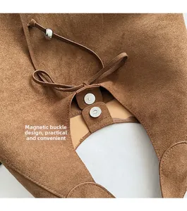 Detail of brown suede tote bag showing secure magnetic buckle and fine stitching