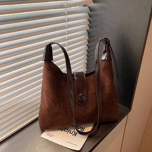 Vintage dark brown suede tote bag with leather straps and elegant window light photography