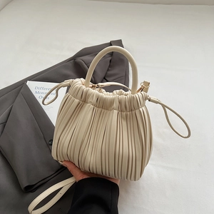 Chic pleated cream cloud handbag with drawstring closure and versatile shoulder strap