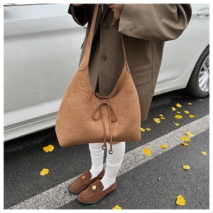 Brown suede tote bag with drawstring detail shown in an autumn street style outfit