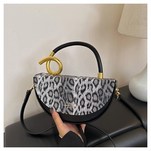 Detail of leopard print handbag featuring elegant gold circular hardware and leather strap