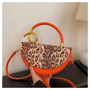 Detail of leopard print flap and orange leather bag with golden knot metal accessory