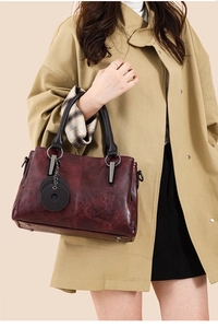 Detail of vintage burgundy tote bag with textured faux leather and metal ring charm