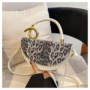 Detail of leopard print flap and gold Mobius hardware on luxury leather handbag