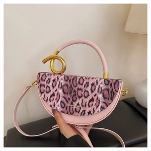 Detail of pink leopard print handbag featuring a gold metal handle and leather strap