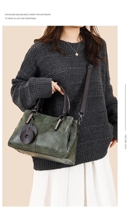 Detail view of dark green oil wax leather tote bag with brown handles and shoulder strap