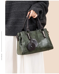 Close-up of vintage dark green tote bag with texture look and round leather pendants