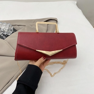 Elegant burgundy leather crossbody bag with gold V-detail and chain strap displayed