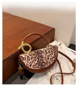 Detail of leopard print handbag with golden spiral hardware on circular handles