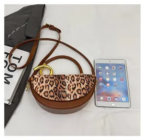 Detail view of leopard print crossbody bag showing gold ring handle and interior space