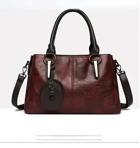 Close-up of wine red retro tote bag with smooth texture and silver metal buckles