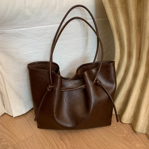 Large dark brown tote bag with drawstring knot straps and pleated faux leather texture