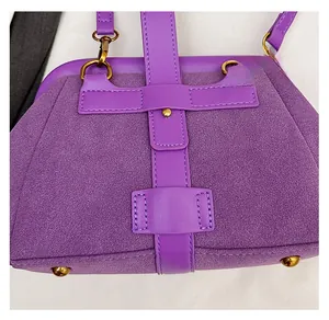 Detail of purple frosted suede shell bag featuring gold metal studs and precision stitching