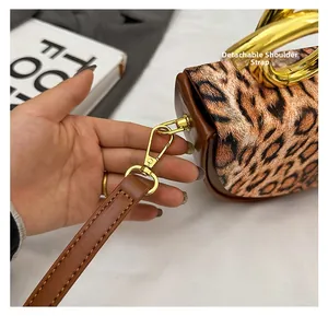 Detail of detachable shoulder strap with gold-tone lobster clasp on leopard print handbag