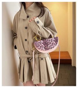 Detail of pink leopard print handbag with golden circular handle and shoulder strap