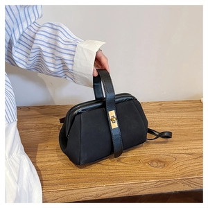 Detail of matte shell bag with golden buckle closure and elegant leather strap