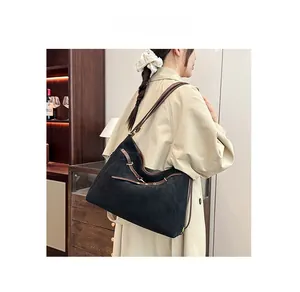 Détail du grand sac cabas en daim noir avec bretelles en cuir marron et boucles