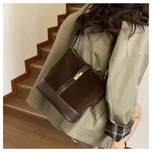 Detail of retro dark brown shoulder bag with suede patchwork and gold buckle closure