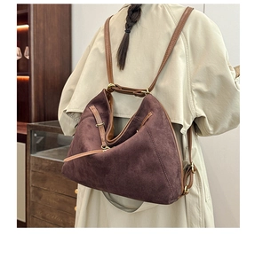 Détail du sac bandoulière en daim montrant le tissu texturé et la sangle en cuir