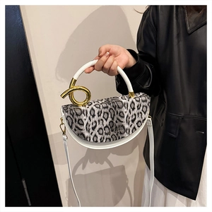 Detail of leopard print handbag with metallic handle and white leather body