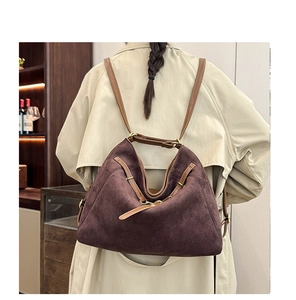 Détail du sac à bandoulière en daim marron vintage montrant texture et lanières