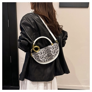 Detailed close-up of leopard print handbag with white round handle and gold hardware
