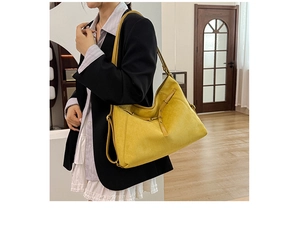 Détail d'un sac à bandoulière en daim jaune vif avec boucle en métal réglable sur la sangle