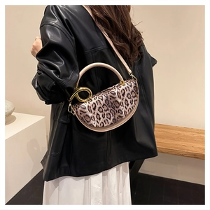 Leopard print crossbody bag with gold handle shown on model in black leather jacket