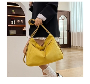 Détail du sac à main jaune en suédine montrant la boucle dorée et la texture du tissu