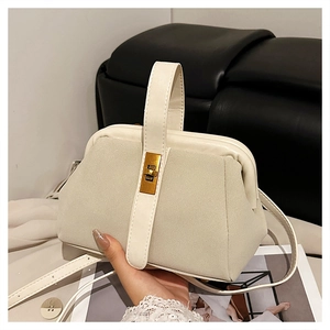 Detailed shot of beige matte suede doctor bag with golden clasp and top handle