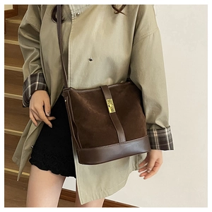 Detail of vintage dark brown bucket bag featuring suede leather contrast and golden turn-lock
