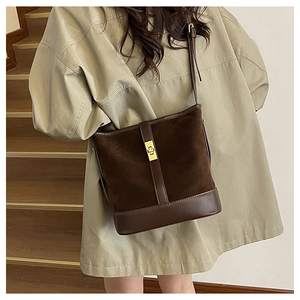 Detail of vintage brown suede shoulder bag with gold buckle and adjustable strap
