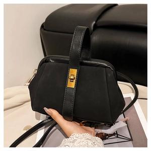 Detail of black frosted shell bag with vintage gold turn-lock and suede texture finish