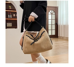 Vue détaillée du sac cabas en daim kaki avec bandoulières noires et boucle rétro sur l'épaule