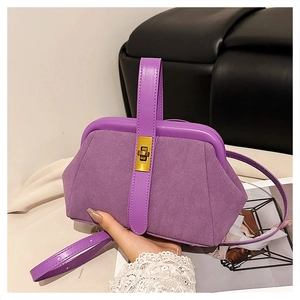 Close-up of purple matte shell bag featuring golden metal twist lock and suede texture