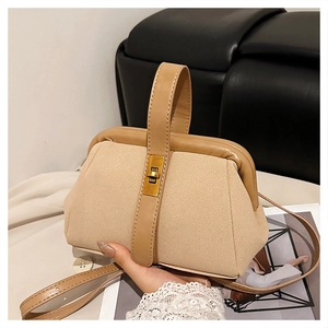 Detail view of beige matte shell bag with leather trim and gold twist-lock closure