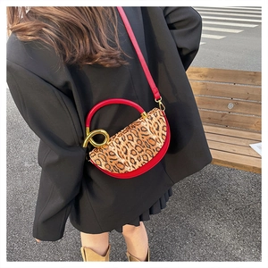 Street style view of leopard print and red leather crossbody bag with gold hardware detail