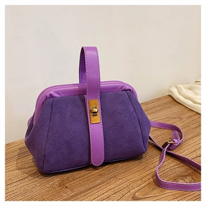 Detailed close-up of purple frosted suede shell bag with golden metal twist lock