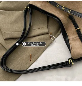 Détail d'un sac bandoulière en daim marron avec poignée en cuir noir et œillets dorés