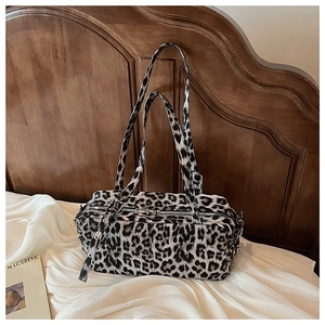 Detail of leopard print bowling bag with silver zipper on white satin fabric