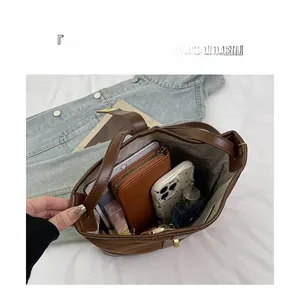 Internal view of a brown leather canvas bucket bag showing high capacity for essentials