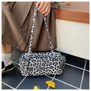 Close-up of leopard print bowling bag with vintage metal eyelets and silver zippers