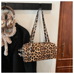 Detail of leopard print bowling bag featuring metal adjustment buckles and dual straps