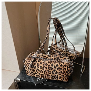 Detail view of the leopard print handbag texture and adjustable shoulder straps with buckles