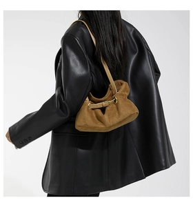 Detail of brown faux suede tote bag with stylish buckle and vintage pleated texture