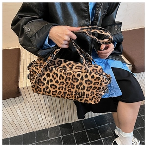 Close-up of leopard print bowling bag with leather strap on a model's shoulder