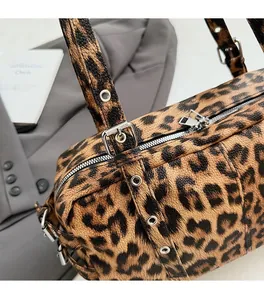 Detail of leopard print bowling bag with silver hardware and eyelet shoulder strap