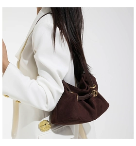 Detail of dark brown faux suede tote bag with gold ring and drawstring on model