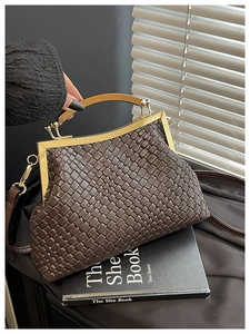 Détail du sac en cuir tressé avec cadre en métal doré et poignée en bois vintage